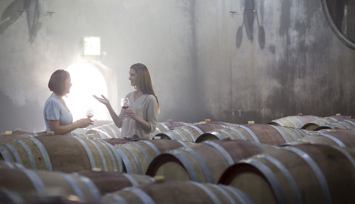two women with wine barrels