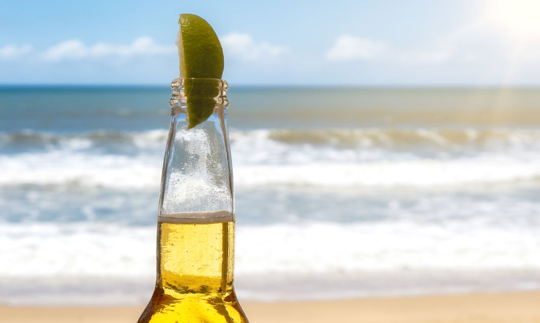 bottled beer on the beach with lime