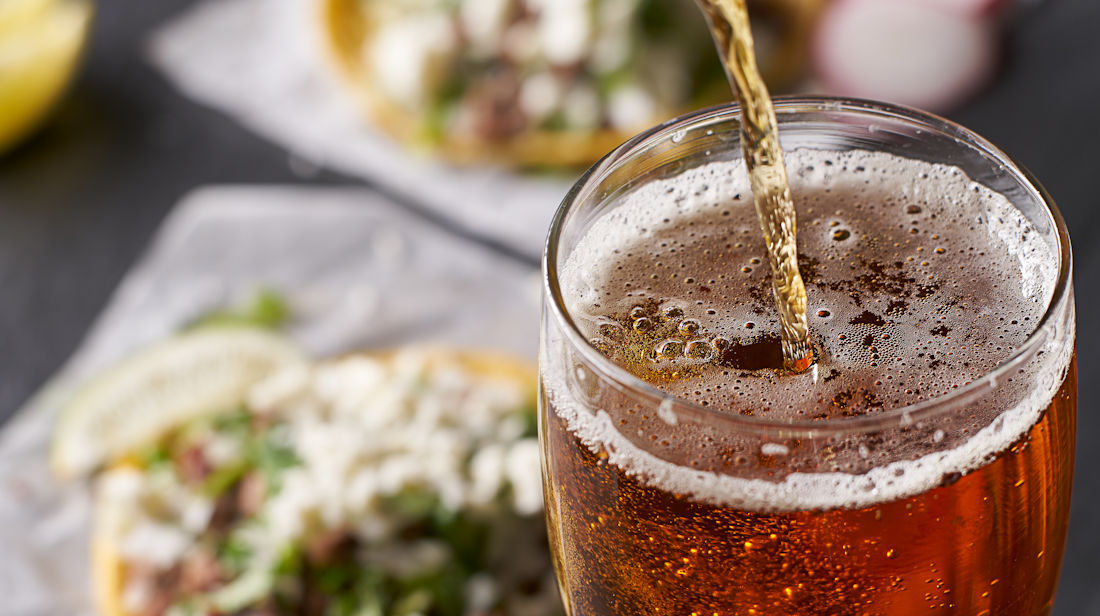 pouring a beer with tacos